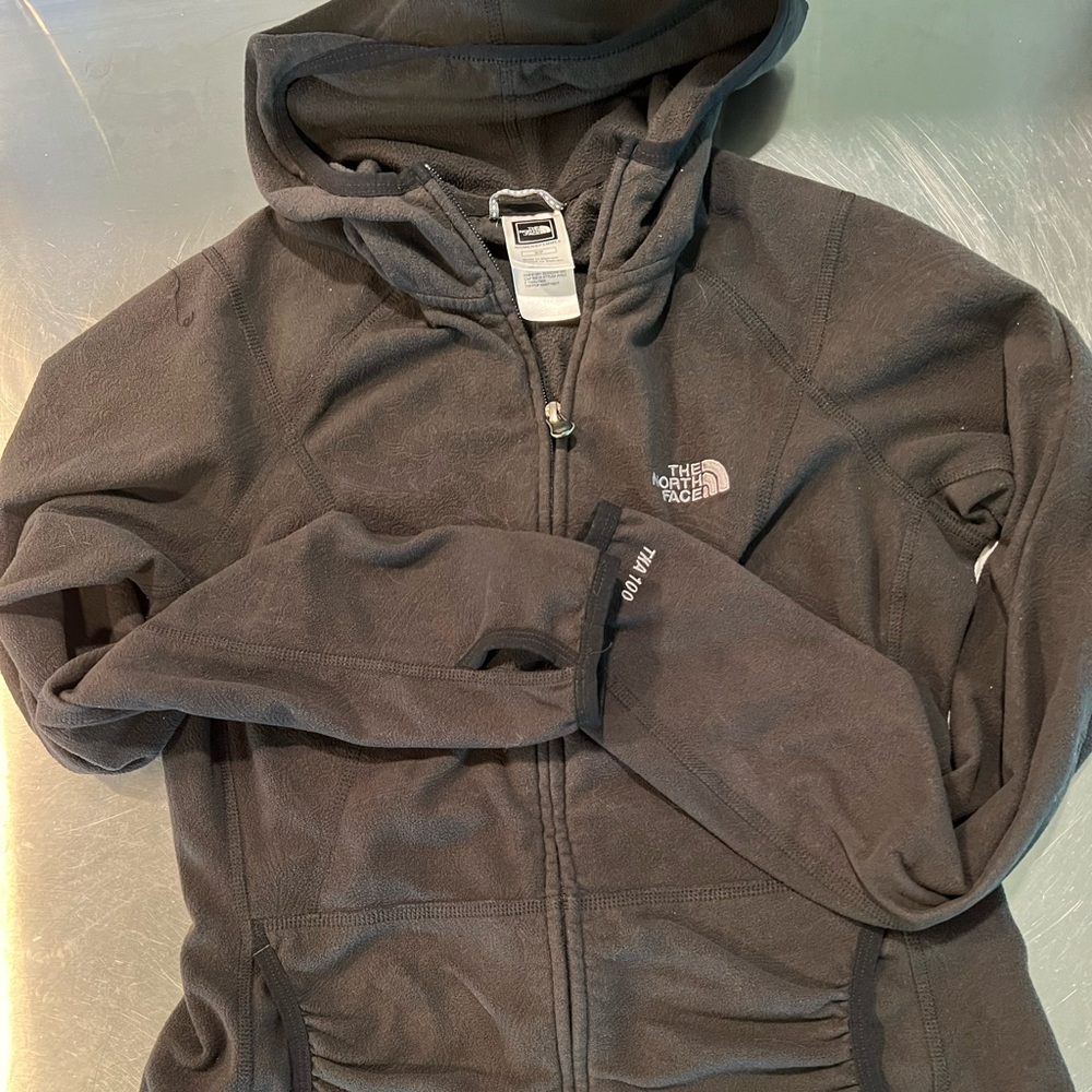 North face Small, embossed pattern, black fleece, front pockets with hood.